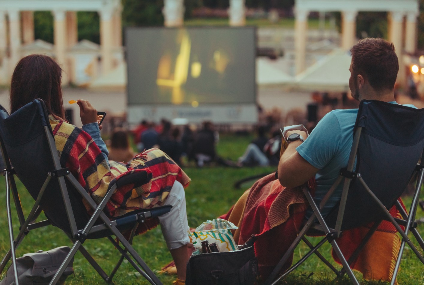 A decorative element: a couple sitting on deckchairs and watching a film at an outdoor cinema