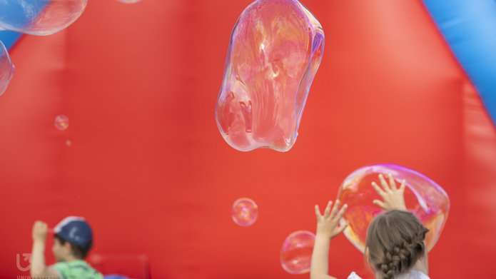 Children running among soap bubbles
