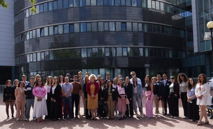 students and lecturers posing for a photo in front of the faculty building