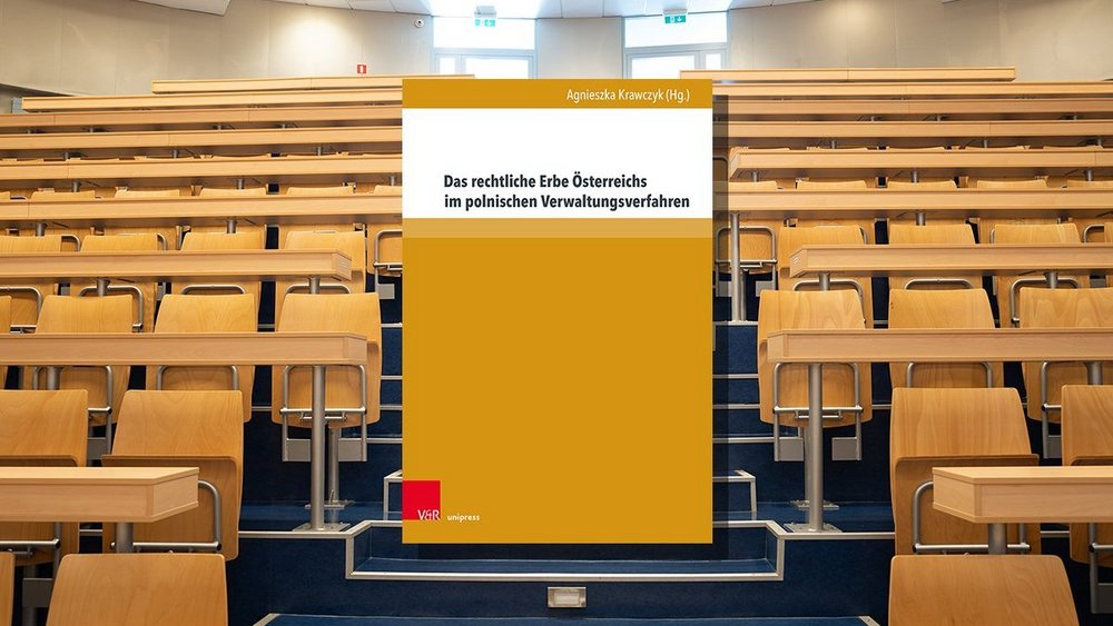 Książka na tle auli akademickiej.