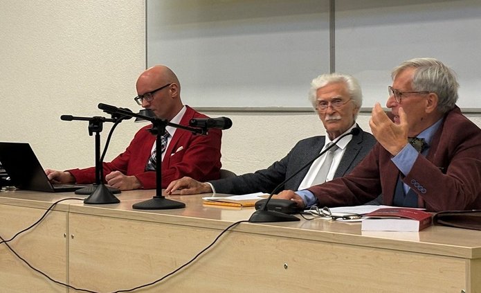 Men in jackets in a lecture hall