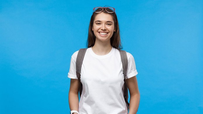 Studentka z plecakiem na niebieskim tle.