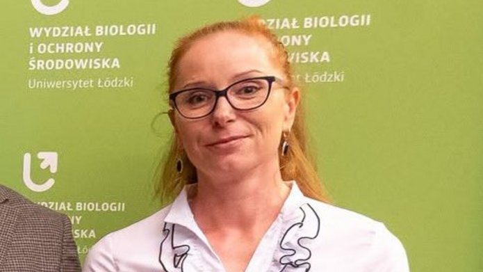 Dziekani w czarno-zielonych togach oraz trzy wyróżnione osoby z dyplomami