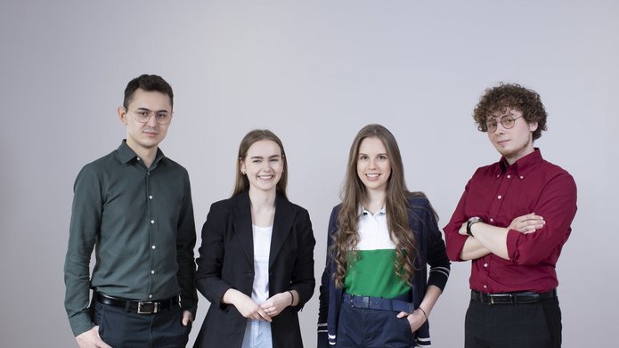 Czwórka studentów pozuje do zdjęcia