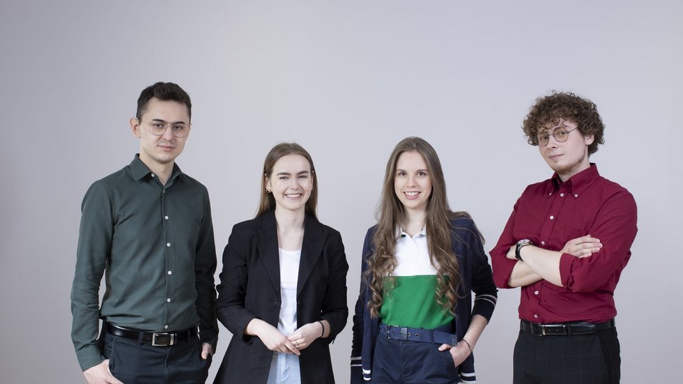 Czwórka studentów pozuje do zdjęcia