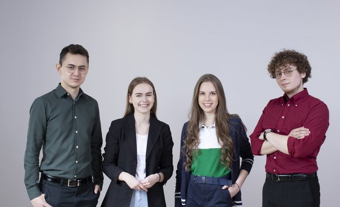 Czwórka studentów pozuje do zdjęcia