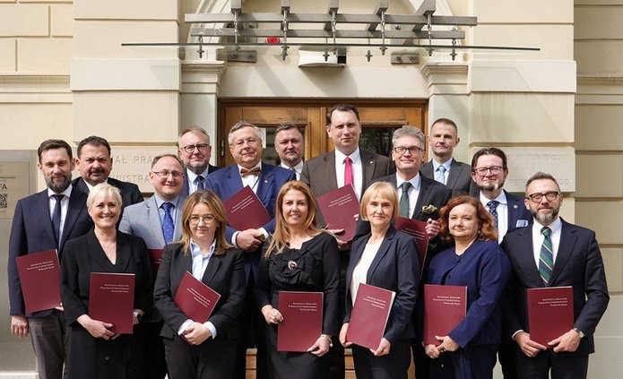 Grupa ludzi trzymająca podpisane porozumienia