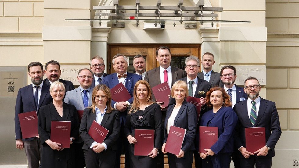 Grupa ludzi trzymająca podpisane porozumienia